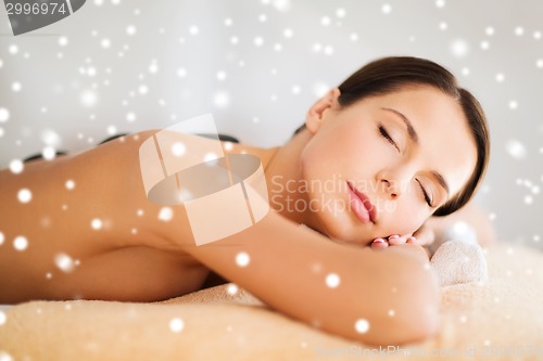 Image of woman in spa salon with hot stones