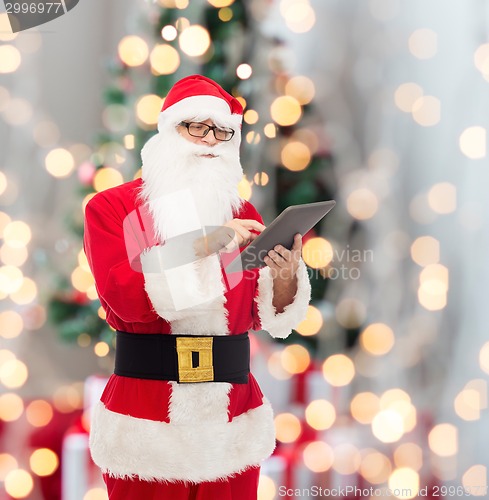 Image of man in costume of santa claus with tablet pc