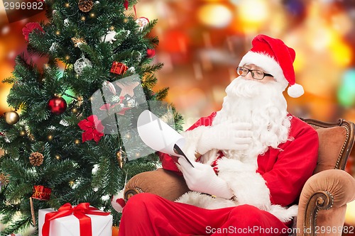 Image of man in costume of santa claus with notepad