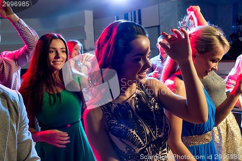 Image of smiling friends dancing in club