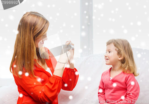Image of smiling mother and daughter with camera