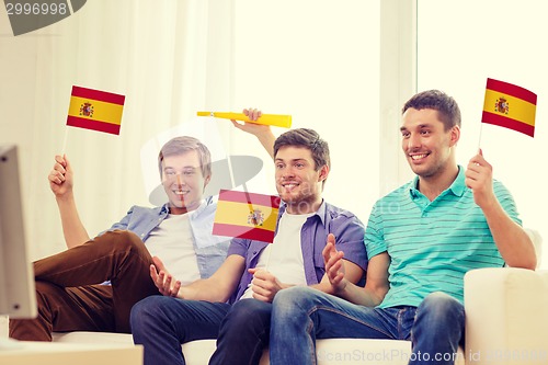 Image of happy male friends with flags and vuvuzela