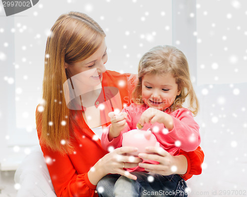 Image of mother and daughter with piggy bank