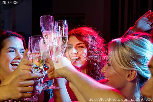 Image of smiling friends with glasses of champagne in club