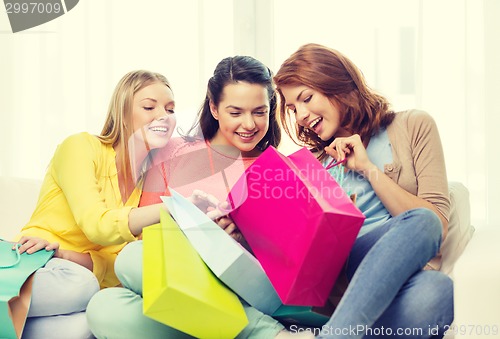 Image of smiling teenage girls with many shopping bags