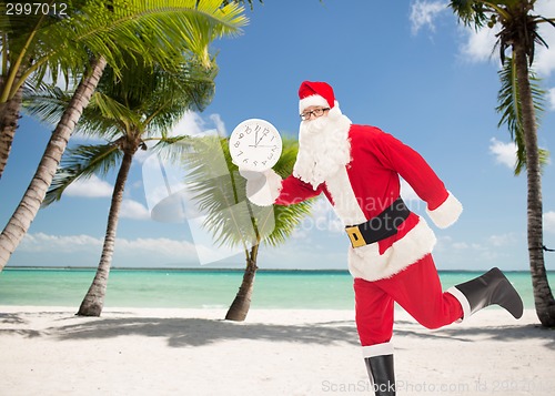 Image of man in costume of santa claus with clock