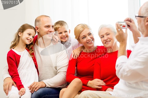 Image of smiling family with camera at home