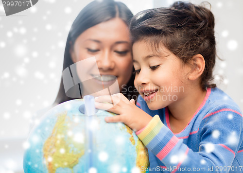 Image of mother and daughter with globe indoors