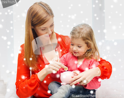 Image of mother and daughter with piggy bank