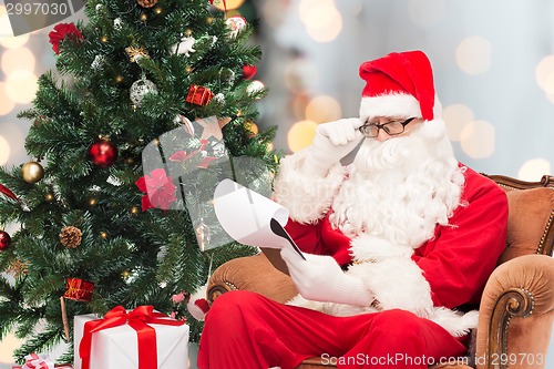 Image of man in costume of santa claus with notepad