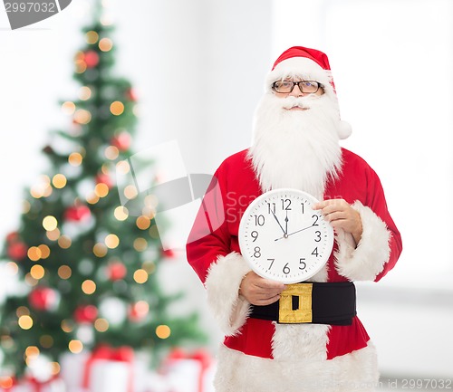 Image of man in costume of santa claus with clock