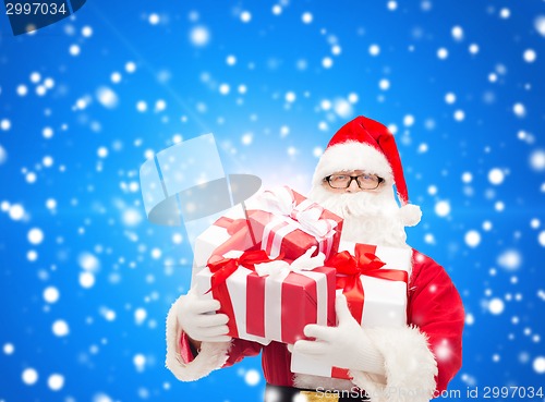Image of man in costume of santa claus with gift boxes