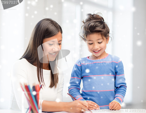 Image of mother and daughter with coloring pencils indoors