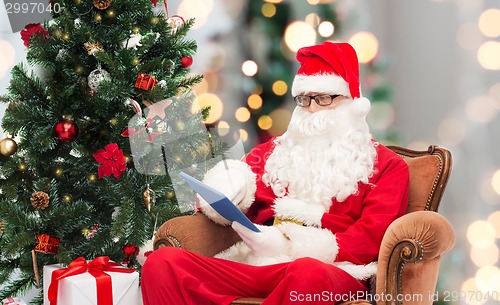 Image of man in costume of santa claus with tablet pc