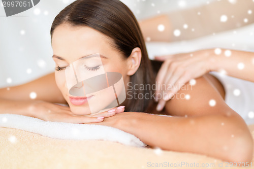 Image of beautiful young woman in spa salon getting massage