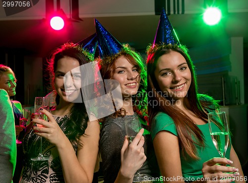 Image of smiling friends with glasses of champagne in club