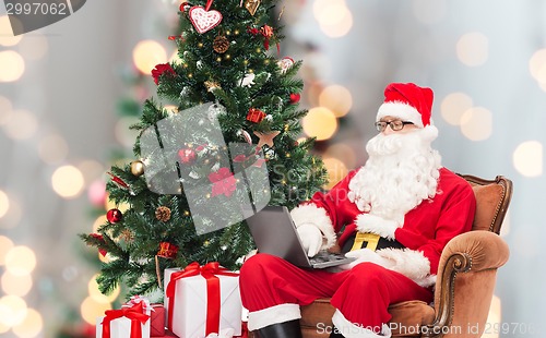 Image of man in costume of santa claus with laptop