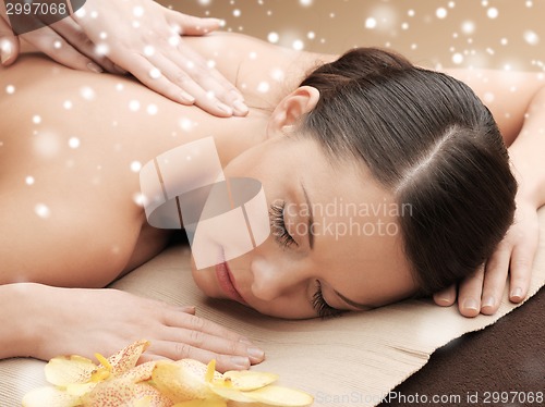 Image of beautiful young woman in spa salon getting massage