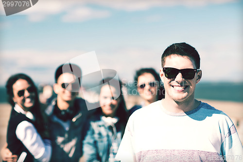 Image of teenager in shades outside with friends