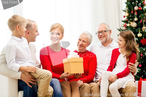 Image of smiling family with gifts at home