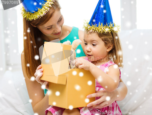 Image of mother and daughter in party hats with gift box