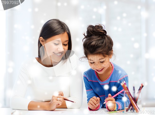 Image of mother and daughter with coloring pencils indoors