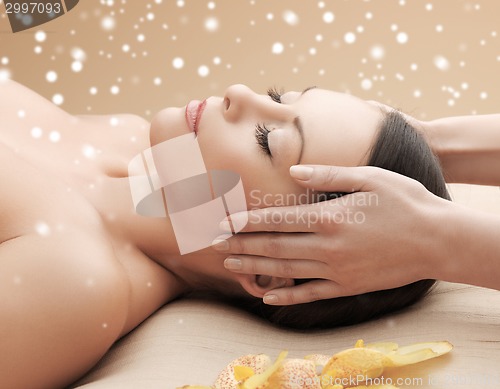 Image of beautiful woman getting face or head massage