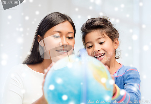 Image of mother and daughter with globe indoors