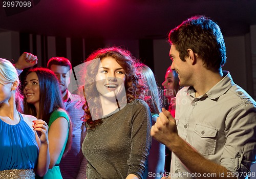 Image of smiling friends dancing in club