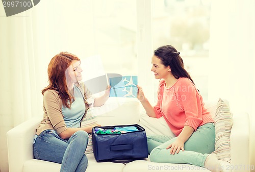 Image of two smiling teenage girls with plane tickets