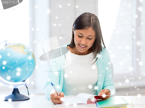 Image of smiling young woman with globe and tablet pc