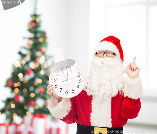 Image of man in costume of santa claus with clock