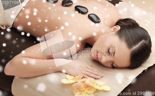 Image of woman in spa salon with hot stones