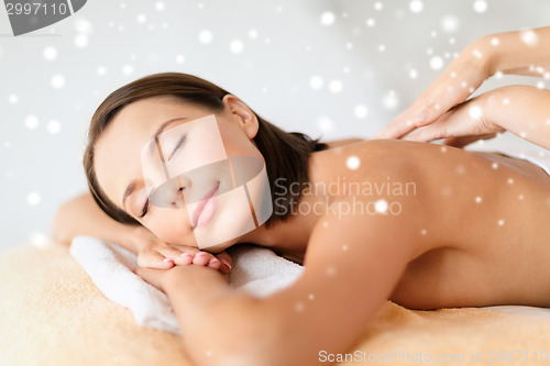 Image of beautiful young woman in spa salon getting massage