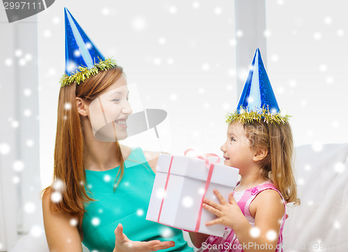 Image of mother and daughter in party hats with gift box