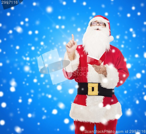 Image of man in costume of santa claus with notepad