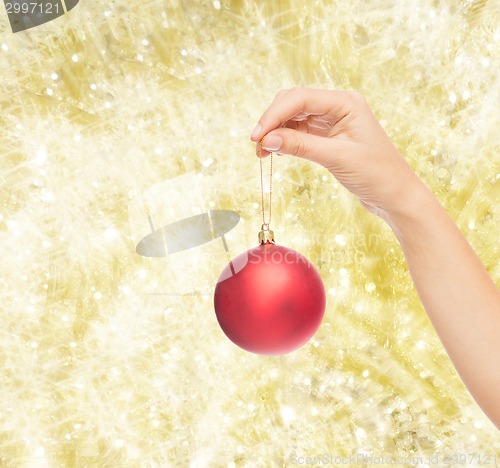 Image of close up of woman in sweater with christmas ball