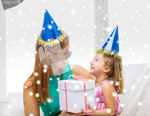 Image of mother and daughter in party hats with gift box