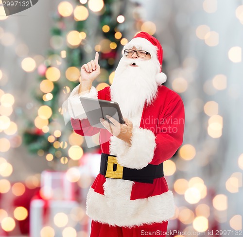 Image of man in costume of santa claus with tablet pc