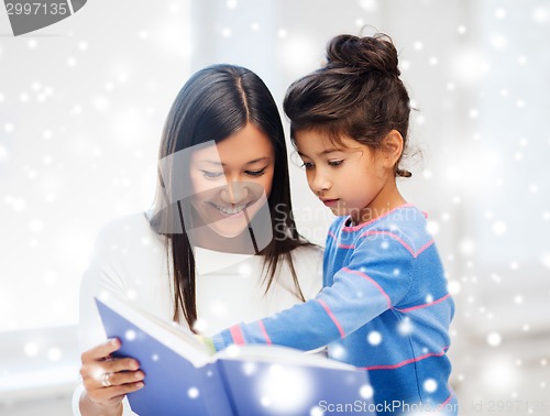 Image of mother and daughter with book indoors