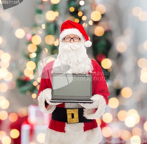 Image of man in costume of santa claus with laptop