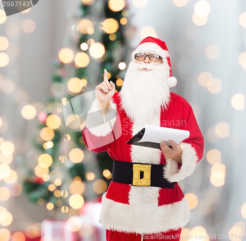 Image of man in costume of santa claus with notepad