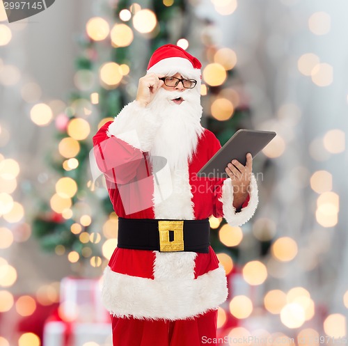 Image of man in costume of santa claus with tablet pc