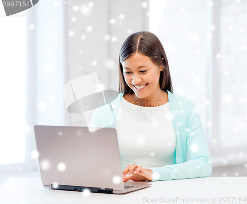 Image of smiling young woman with laptop
