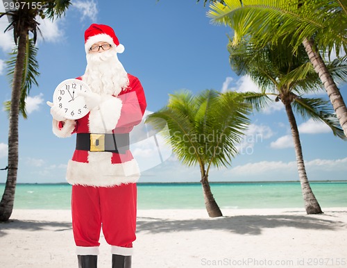 Image of man in costume of santa claus with clock