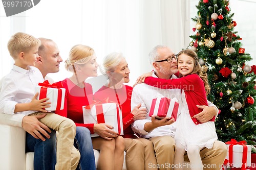 Image of smiling family with gifts at home