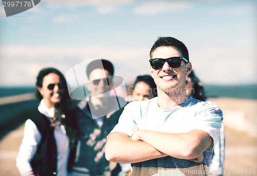 Image of teenager in shades outside with friends