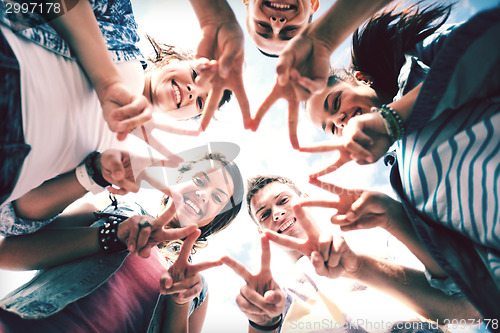 Image of group of teenagers showing finger five