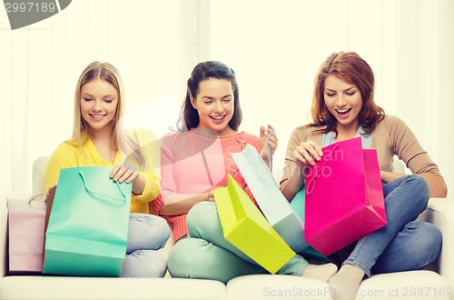 Image of smiling teenage girls with many shopping bags