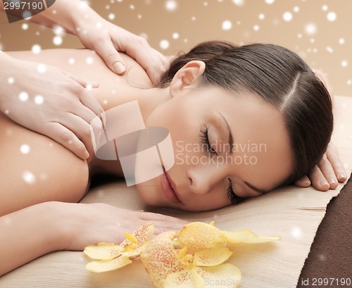 Image of beautiful young woman in spa salon getting massage